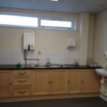Village hall kitchen facilities, with water heater, storage, dual-sink and hand-washing station