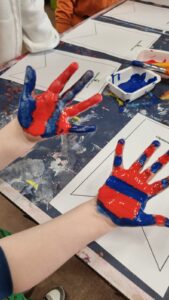 Photo of child's hands with paint on them.
